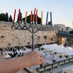 Lighting Hanukkah candles in front of the Kotel in Jerusalem