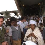 An IDF officer helps Ethiopian immigrants off the plane during Operation Solomon | Photograph: Israeli Tsvika, GPO, May 1991.