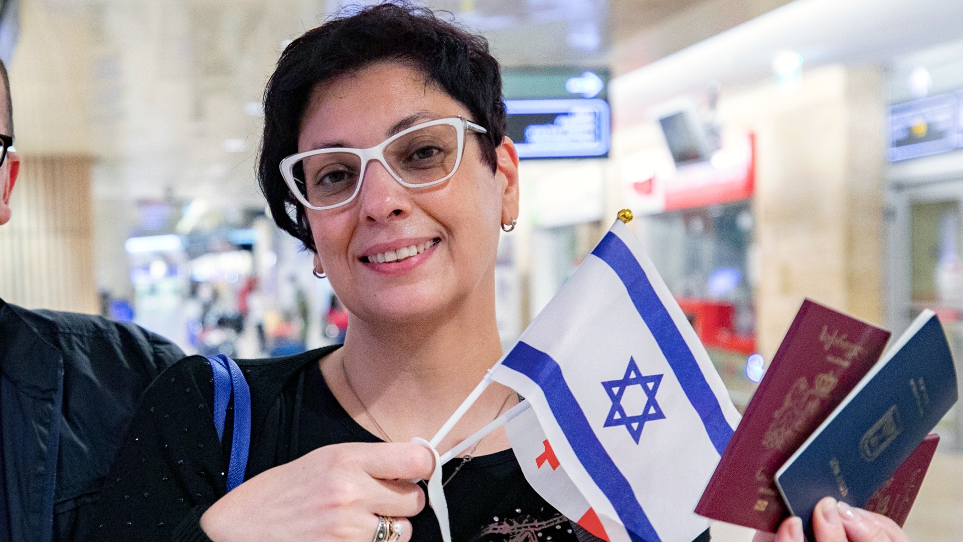 new immigrant in Israel holds flags and passports