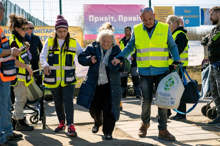 Jewish Agency staff help an elderly Ukrainian woman at the border