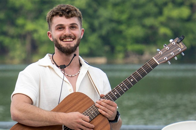 Shachaf with a guitar at camp