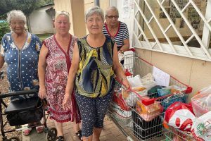 Amigour residents stand with items they are organizing into packages for those impacted by terror in Israel