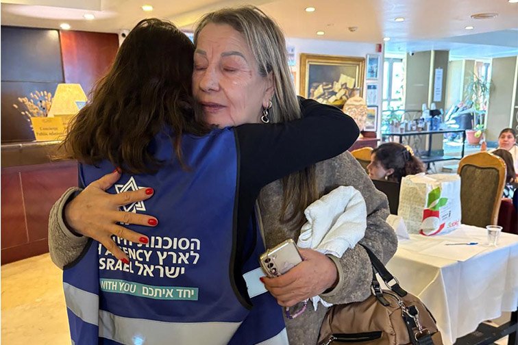 Chana, a victim of the recent missile attacks, hugs a Jewish Agency representative
