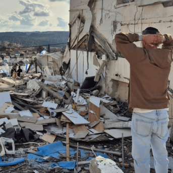 A man looks at his destroyed home